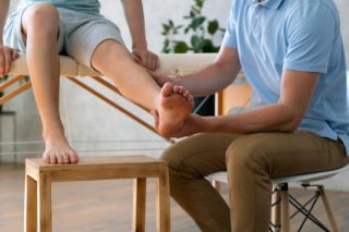 CLOSE UP DOCTOR HOLDING LEG